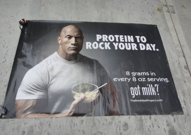 Dwayne 'The Rock' Johnson promoting milk with "Protein to rock your day." School marketing image.