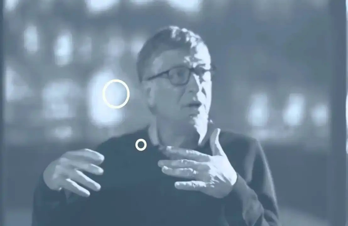 Bill Gates gesturing while speaking, discussing productivity and hunger solutions.