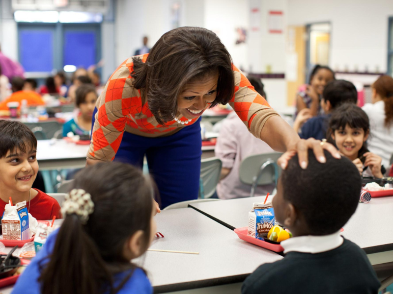 Michelle Obama interacts with elementary school students during lunchtime.