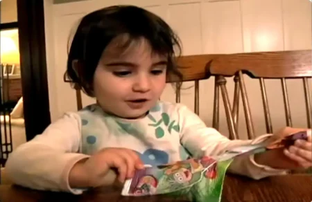 Child opening colorful cartoon character snack package