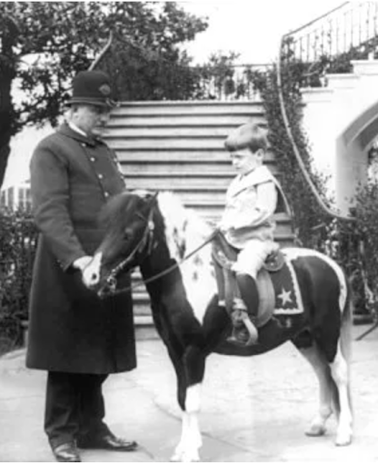 Theodore Roosevelt with a boy on a pony.