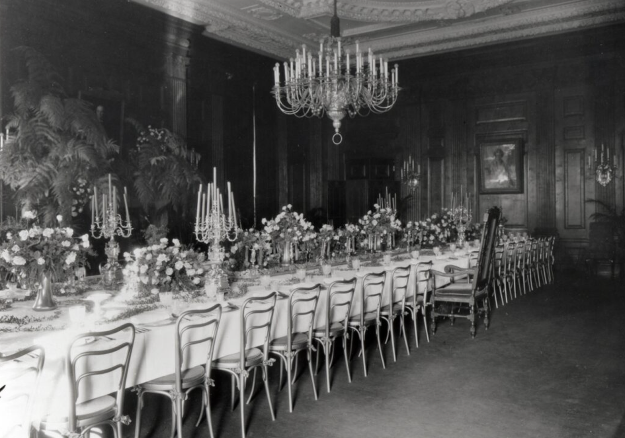 Formal dining room with long table set for a banquet, possibly during Calvin Coolidge's presidency.