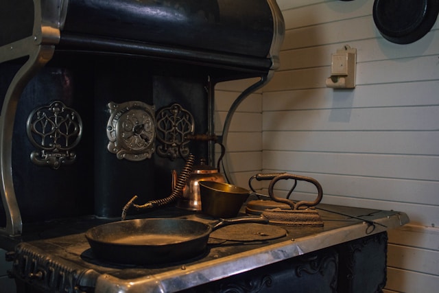 Antique cast iron stove with cookware, reminiscent of Millard Fillmore's era.