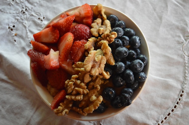 Bowl of strawberries, blueberries, and walnuts, a healthy breakfast