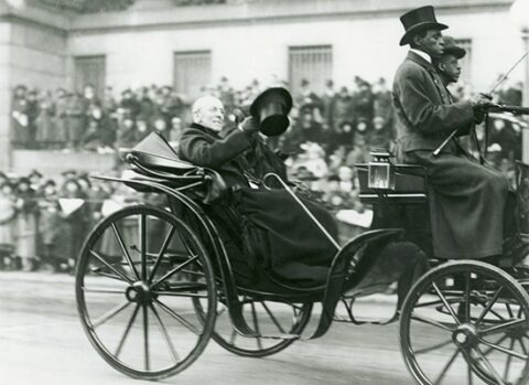 Woodrow Wilson in a carriage, waving to a crowd
