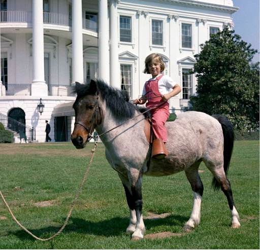 Caroline Kennedy rides her pony Macaroni on the White House lawn.