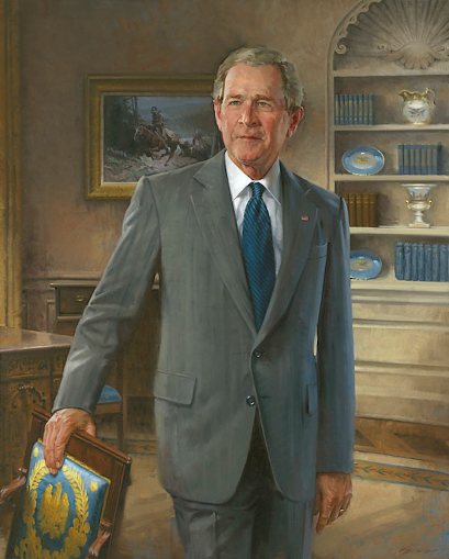 Official portrait of George W. Bush in a gray suit, standing in the Oval Office.