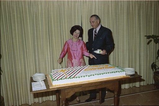 Lyndon B. Johnson and Lady Bird Johnson cut a Merry Christmas cake.