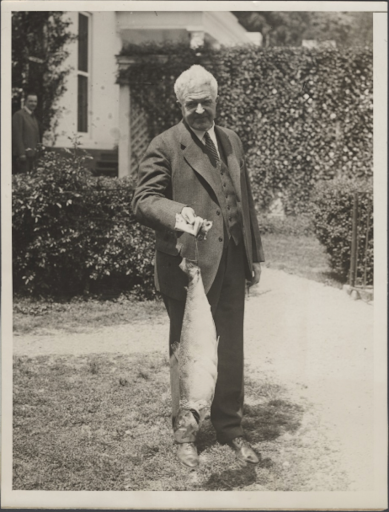 Herbert Hoover proudly holds a large fish he caught.
