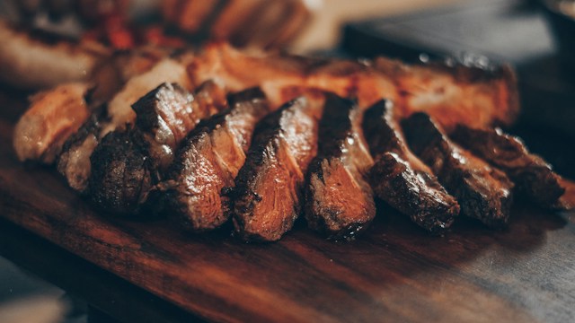 Sliced grilled steak on a wooden board